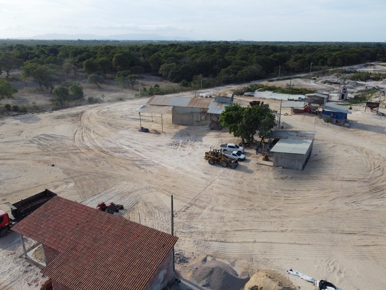 Vista aérea dos galpões e da pá carregadeira da planta
